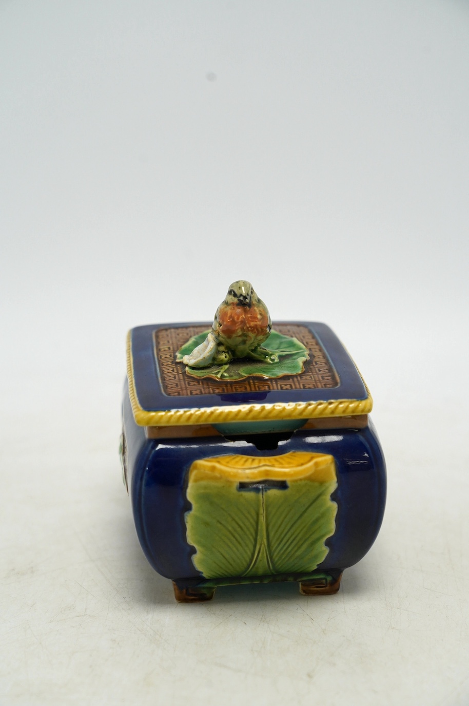 A small Minton majolica box and cover, possibly after a design by Christopher Dresser, 13cm wide. Condition - poor